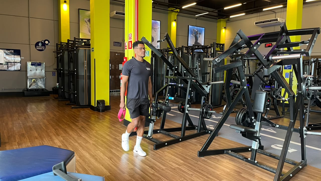 Vitor Serafim caminhando entre os equipamentos da academia